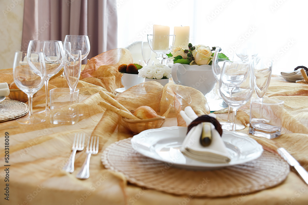 Detail of a table set in ocher color organza for a wedding banquet Detail of a table set in ocher color organza for a wedding banquet