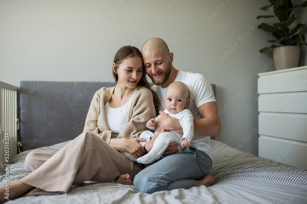  mom and dad enjoy taking care of a little child. happy family.  caucasian smiling mother father and newborn baby Loving parents mom and dad enjoy taking care of a little child. healthy child care