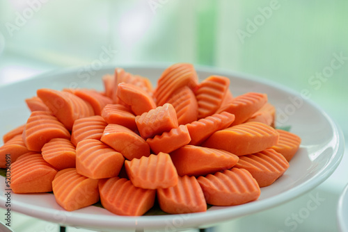 Sliced ripe papaya fruit on white plates ready to eating.