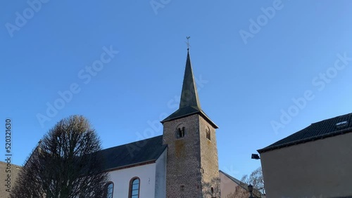 Small catholic church in Vitchen, Luxembourg, viewing the tower up and down again photo