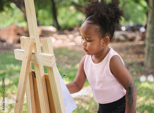 Canvas Print African American kid girl painting in the park