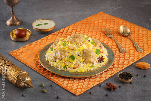Indian spicy food chicken Afghani Tikka Biryani or Reshmi Chicken Tikka biryani with raita and gulab jamun Served in a dish side view ramdan food on grey background photo