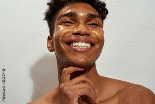 Фототапет Cropped of black guy with golden mask on his face