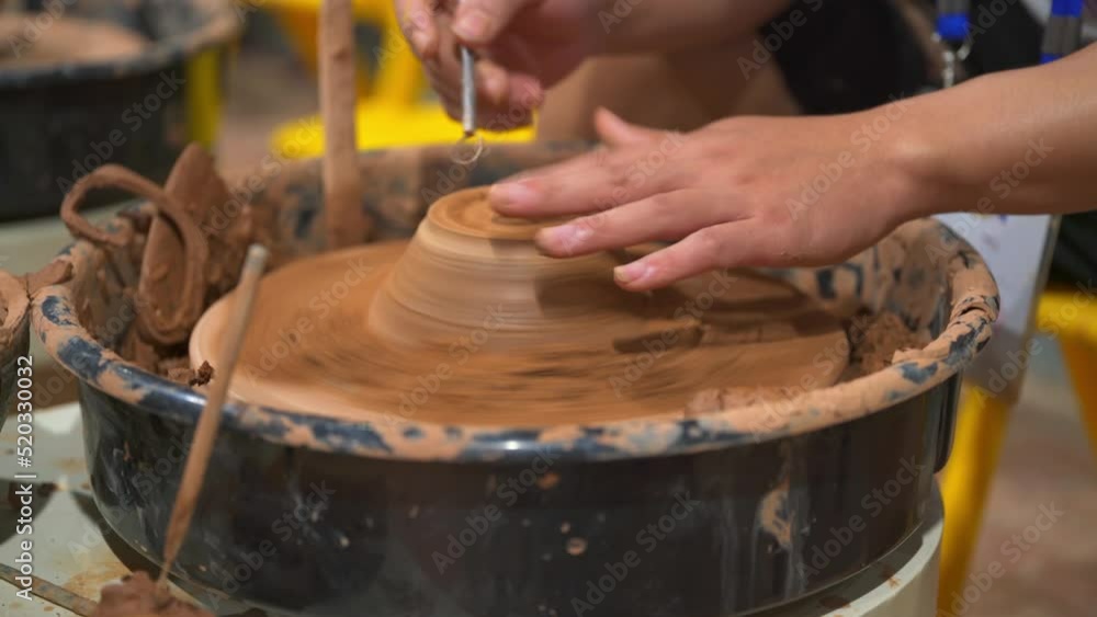 A craftsman in a clay china shop is making clay utensils A craftsman in a clay china shop is making clay utensils
