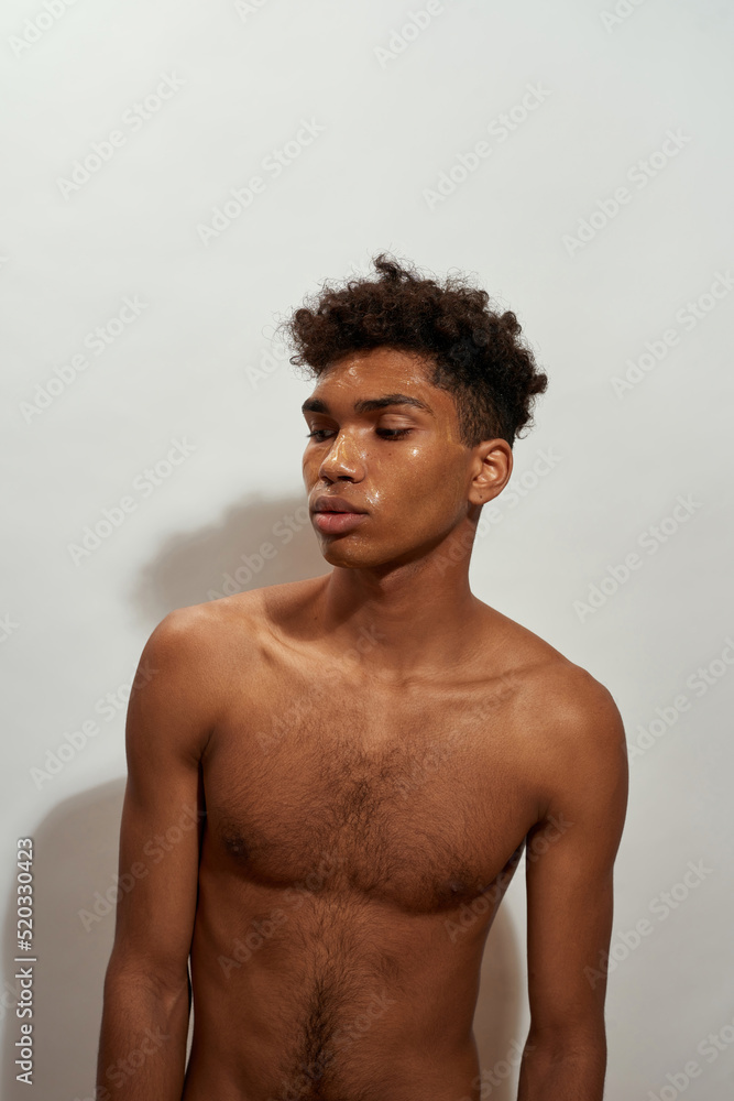 Fototapeta premium Focused black guy posing with golden mask on face