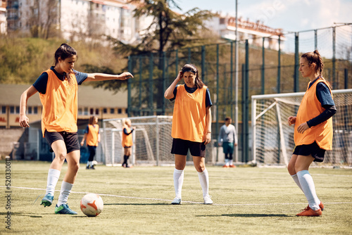 Female soccer player practicing during sports training on playing field. © Drazen
