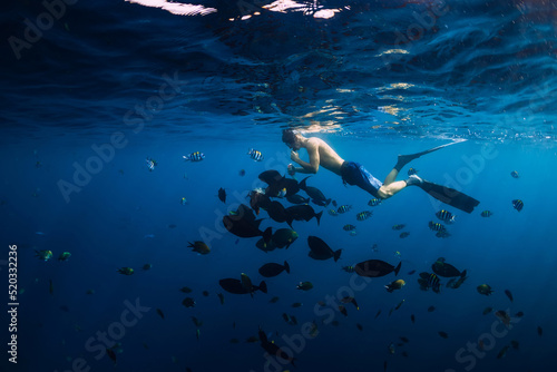 Free diver man with school of fish in transparent ocean © artifirsov