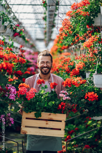 Florist man working with flowers at a plant nursery greenhouse.