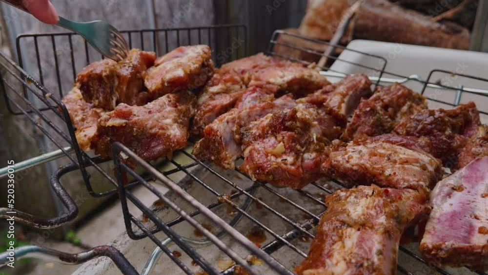 Man laying raw meat on barbecue grill Man laying raw meat on barbecue grill