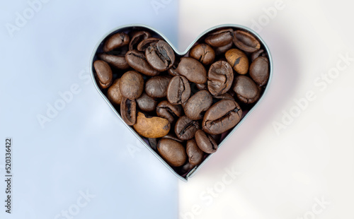 coffee beans vs  in capsules,pods.roasted brown coffee beans in heart shape for cookies and opened coffee pod.isolated on white or light background.sunshine,sun shadows.fresh  beans in capsule © Alexandra