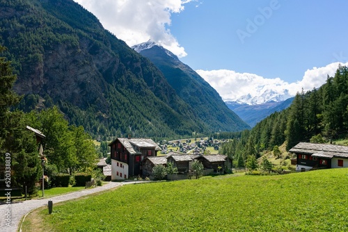 Photo Path descending from mountains to a Swiss valley with a village