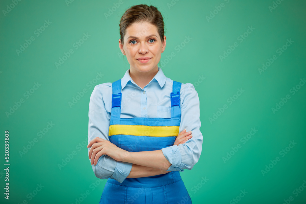 woman worker in overalls with arms crossed. isolated on green background. woman worker in overalls with arms crossed. isolated on green background.