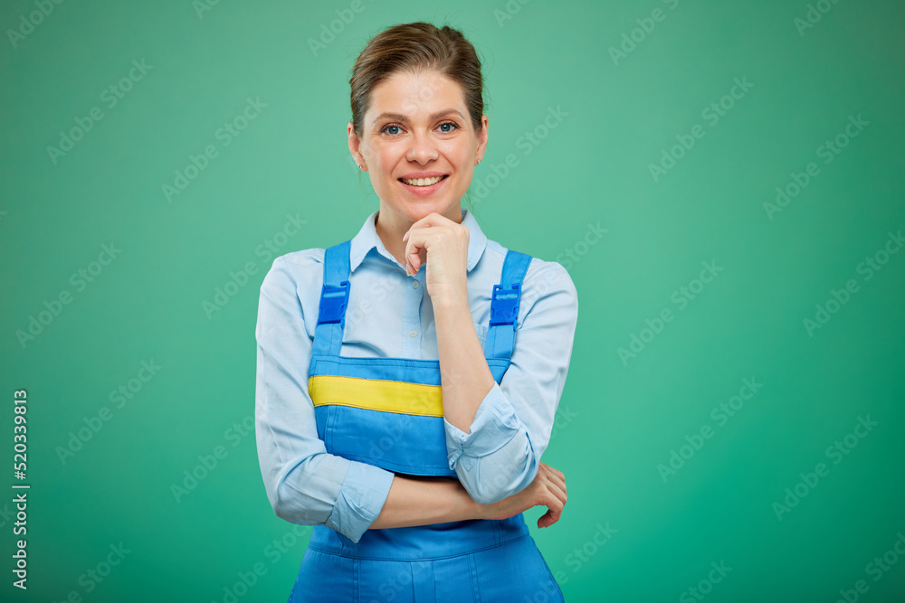 Smiling thinking woman worker in overalls. isolated on green background. Smiling thinking woman worker in overalls. isolated on green background.