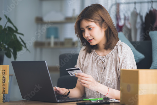 Shot of a lovely female holding a credit card and purchasing online. Beautiful woman buying products in internet. Online shopping and delivery concept