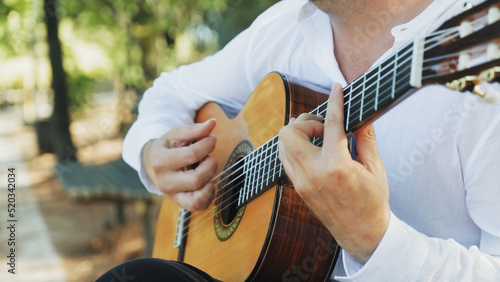 Foto Professional guitarist plays guitar outdoors