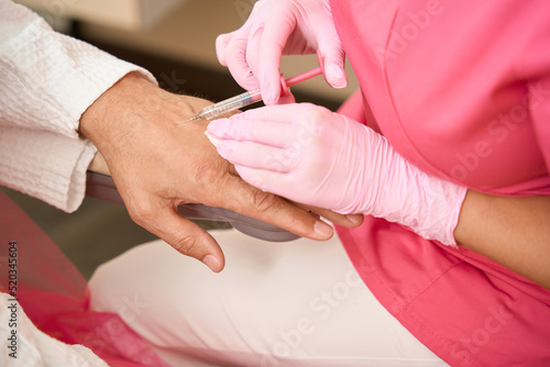 Foto Moment of introduction of beauty injection into arm of man