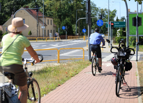 Rower i rowerzyści, mężczyzna i kobieta jadą ścieżką rowerową, skrzyżowanie.