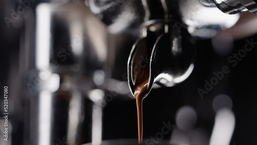 pulling espresso shot with single spout portafilter from coffee machine photo