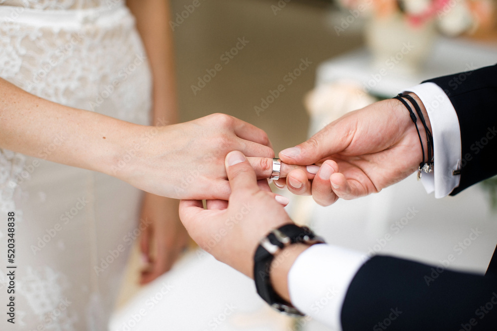 Fototapeta premium Bride and groom exchange rings at the wedding ceremony