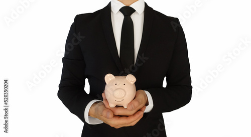 Mann im Anzug mit Sparschwein in der Hand.