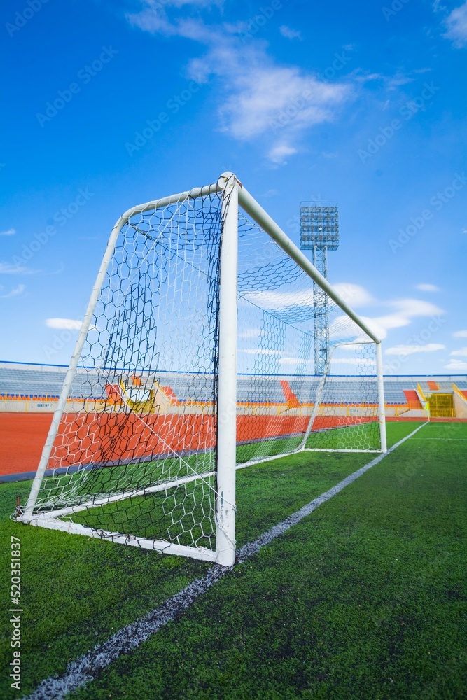 Fototapeta premium STADIUM - Football field with goal and tablo on blue sky