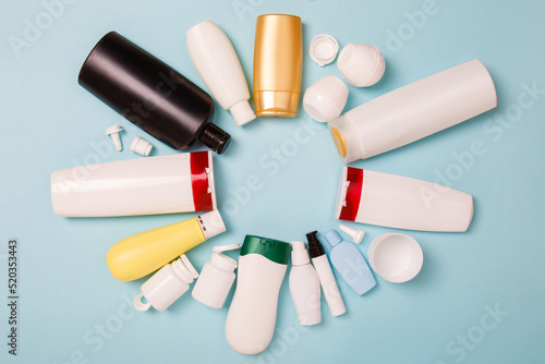 separate collection of sorted HDPE bottles from cosmetics for recycling in for of circle. High-Density Polyethylene recyclable cosmetics package on blue background. Plastic garbage. Save the planet photo