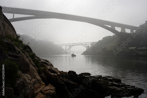 Oporto boat under the foggy bridges