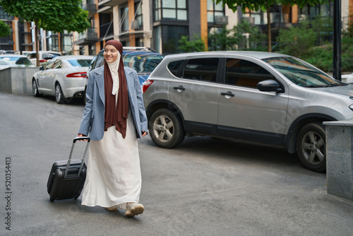 Arab woman with a suitcase walks around the city