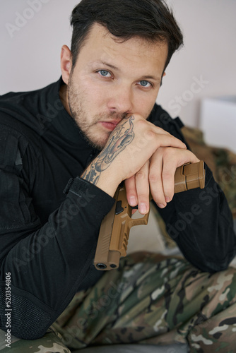 Slika na platnu Ukrainian man soldier with sidearm staring into camera