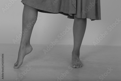 Slender barefoot female legs in black and white