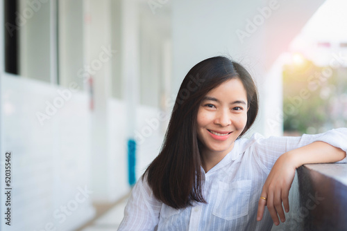 attractive adult business woman asian girl with happy and smile sitting at pole under her office on morning.