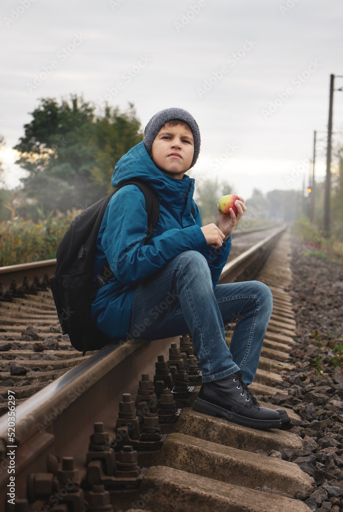 boy sitting on a rails boy sitting on a rails
