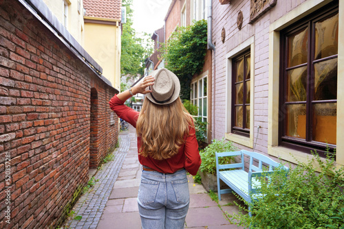 Beautiful tourist girl strolling in Schnoor neighborhood, Bremen, Germany photo