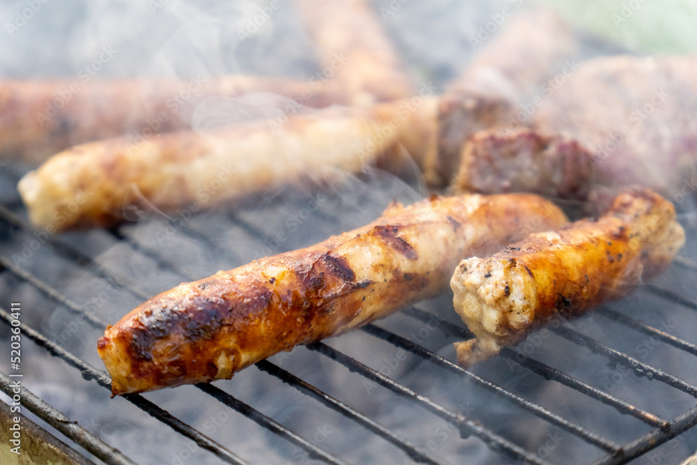 Close up of meat sausages on grill Close up of meat sausages on grill