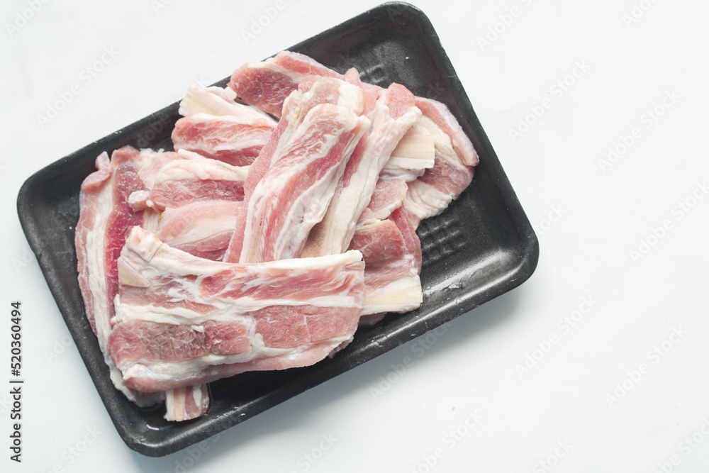 Raw fed bacon strips on white background Raw fed bacon strips on white background
