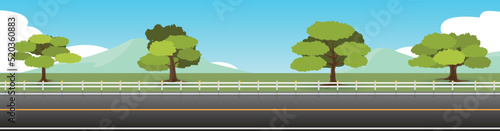 Landscape view of asphalt road.  Background of trees and green grass and mountain. Under the blue sky.
