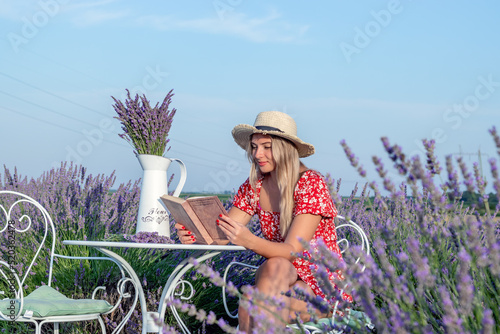 A beautiful young woman enjoys a nice summer afternoon, and a good book in a lavender field.