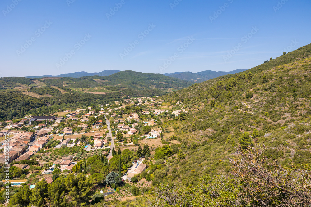 Vue estivale sur les montagnes au-delà de Roquebrun depuis le Jardin Méditerranéen
