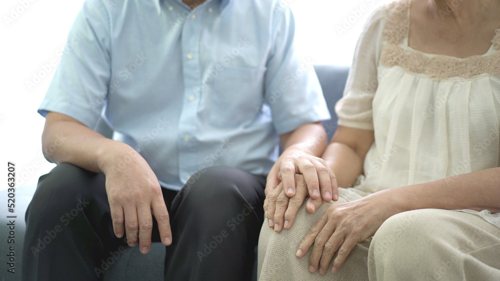 Asian man sitting beside his mother on sofa in hospital while waiting a doctor. Asian man sitting beside his mother on sofa in hospital while waiting a doctor.