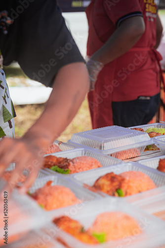 Busy stall selling Nasi Ayam Tomato in takeaway container in Malaysia. photo
