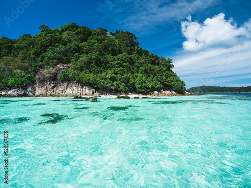 Scenic view of Koh Dong Island breathtaking crystal clear turquoise sea water with coral reef transparent against summer blue sky. Near Koh Lipe Island  Tarutao National Marine Park  Satun  Thailand.