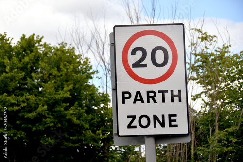 Bilingual road sign showing a 20 mph speed limit at the approach to a village in Wales