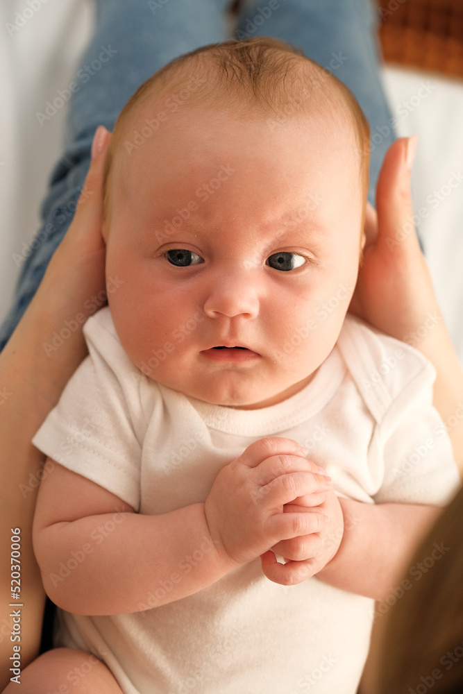 mom holds a newborn baby in her arms. in the background the sun shines from the window. mom holds a newborn baby in her arms. in the background the sun shines from the window.