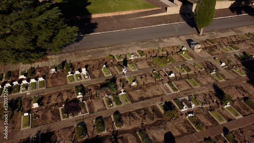 Man consoles sad woman for loss of loved one at Chacarita Cemetery in Buenos Aires, Argentina. Aerial photo