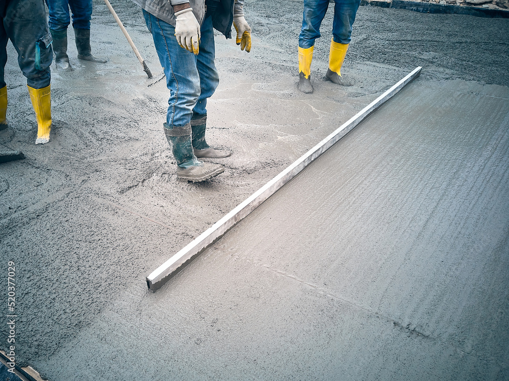 Construction worker uses trowel to level cement mortar screed. Concrete ...