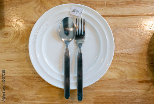 Plate with shiny silver cutlery on grey table  close up.