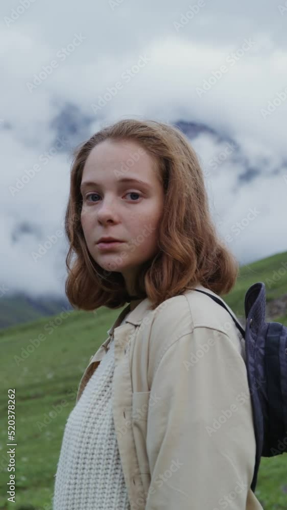 Caucasus, Elbrus. A young woman looks around while standing among mountains Caucasus, Elbrus. A young woman looks around while standing among mountains