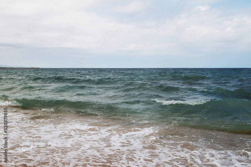 Seascape. Sea coast. Waves. Sea water. Horizon. Sky. Spain. Mediterranean Sea.