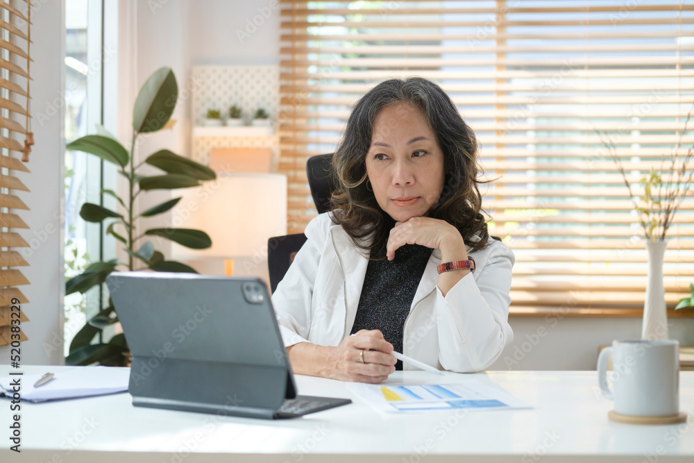 Mature businesswoman working from home, having online video call on digital tablet. Mature businesswoman working from home, having online video call on digital tablet.