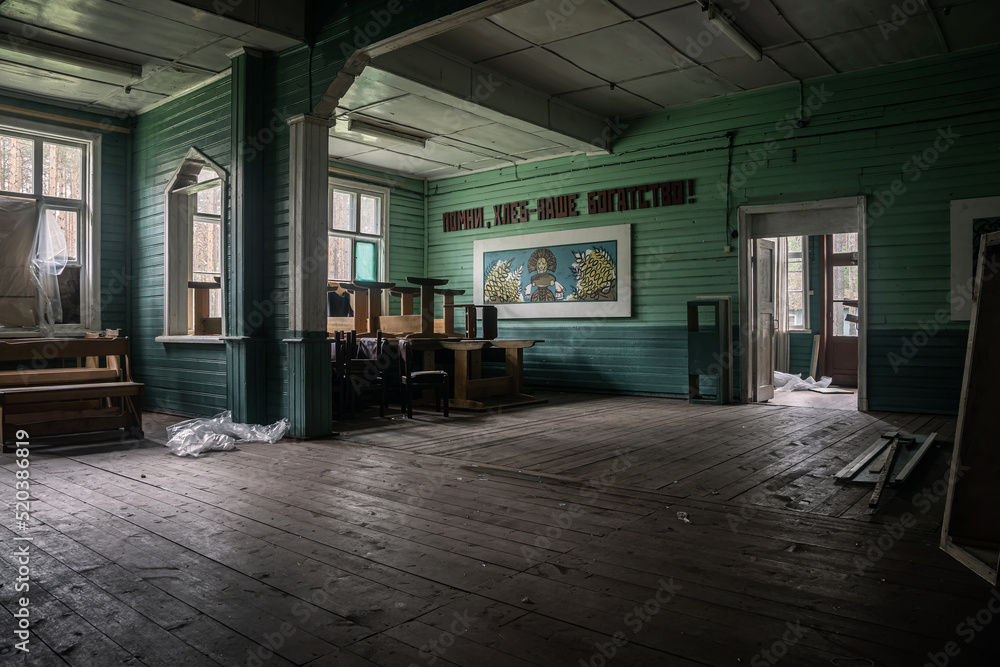 Beautiful interior in an abandoned building. Wooden walls. Drawing on the wall. USSR architecture. Dark atmosphere.